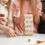 Семья играет в настольные игры за столом дома