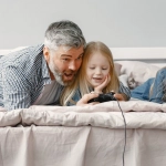 Семья играет в цифровые игры дома вместе с детьми